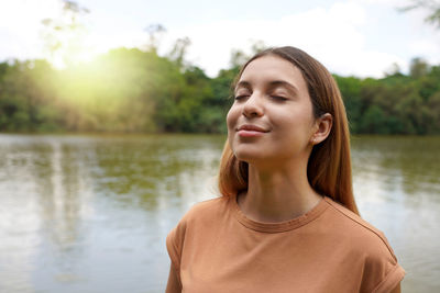 Reconnect with nature. young woman with closed eyes enjoying breathing in tropical park of brazil.