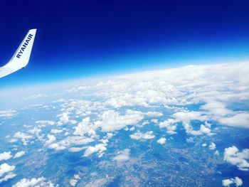 Aerial view of airplane wing against blue sky