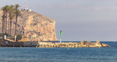 Rocks by sea against sky