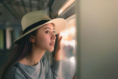 Young woman looking through window in train