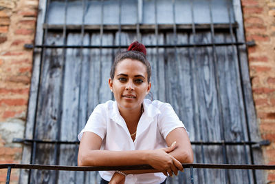 Portrait of young woman leaning on railing