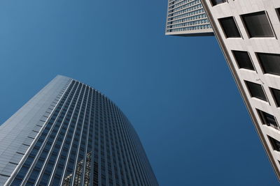 Low angle view of modern buildings against clear blue sky