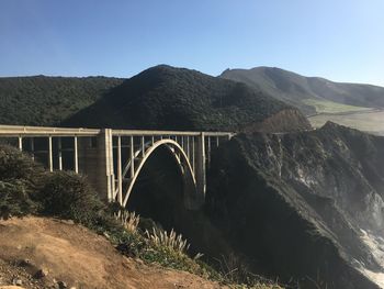 Bridge over mountain against clear sky