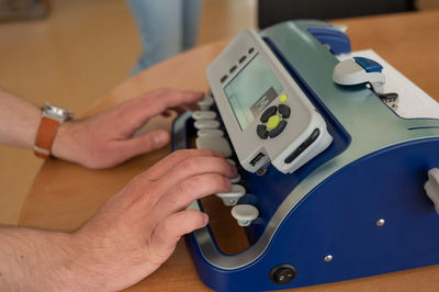 Cropped hand of man repairing machine