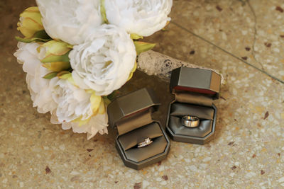 Wedding rings with bouquet on floor