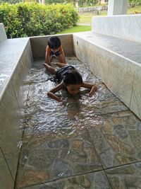 Rear view of siblings in water