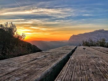 Surface level of footpath against sky during sunset