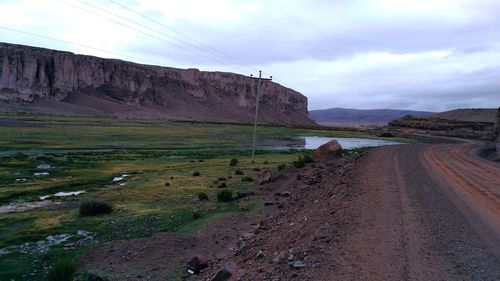 Scenic view of road by land against sky