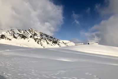 Scenic view of snow covered mountains against sky