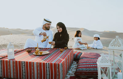 People sitting on table against sky