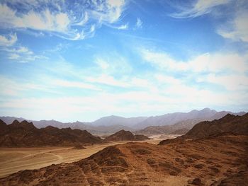 Scenic view of mountains against cloudy sky