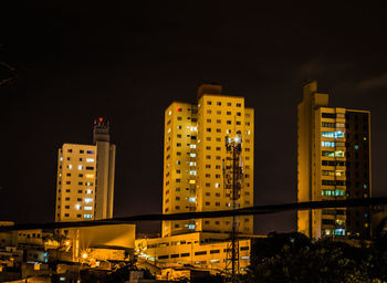 Low angle view of illuminated buildings against sky at night