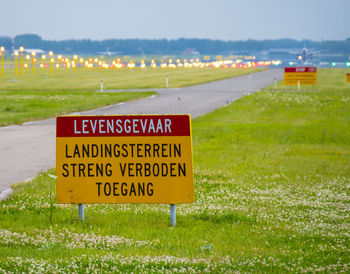 Information sign on field against sky