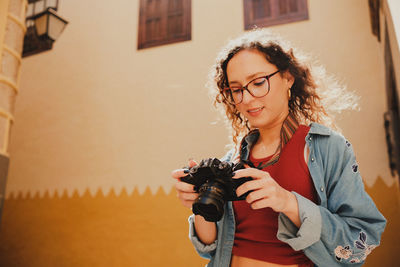 Side view of young woman using mobile phone at home
