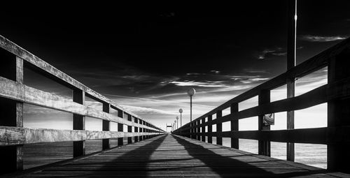 Footbridge over footpath against sky