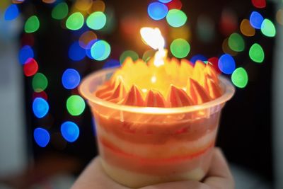 Close-up of hand holding candles