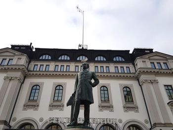 Low angle view of statues on building against sky