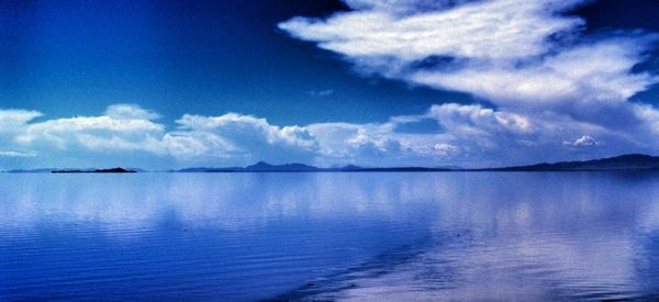 Scenic view of calm lake against cloudy sky