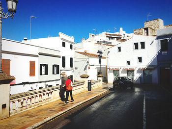 Man on street against buildings in city