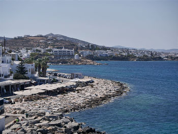 Aerial view of city by sea against clear sky