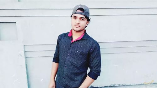 Portrait of young man standing against wall