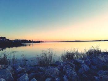 Scenic view of lake against clear sky during sunset