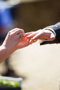 Cropped hand of woman putting ring in man finger