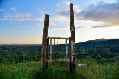 Wooden posts on field against sky