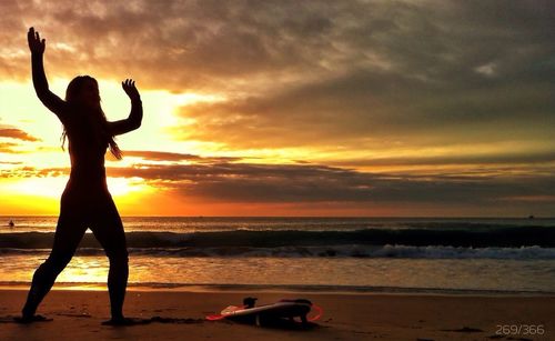Silhouette of people on beach at sunset