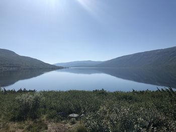 Scenic view of lake and mountains against clear sky