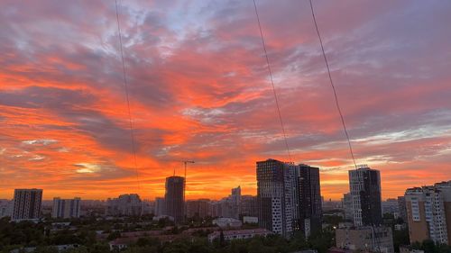 Modern buildings against sky during sunset