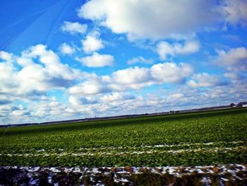 Scenic view of field against cloudy sky