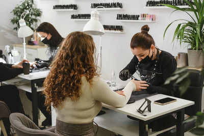 Doing manicure in salon. female manicurist working on client nails in professional salon. occupation