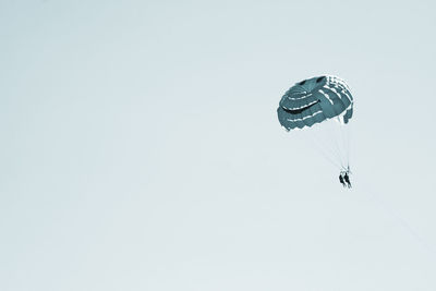 Low angle view of parachute in air against clear sky