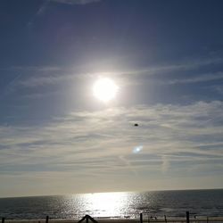 Sun shining through clouds over sea