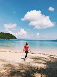 Full length of woman on beach against sky