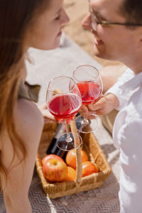 Couple of a man and a woman on a date are walking and drinking wine. a couple in love is relaxing 