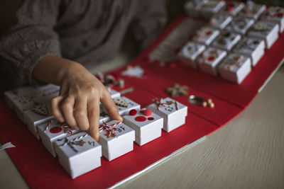 Midsection of girl sitting by christmas gift at home