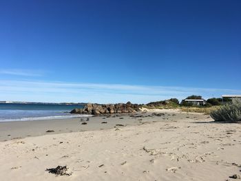 Scenic view of beach against clear blue sky