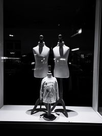 Mannequin in store seen through glass window