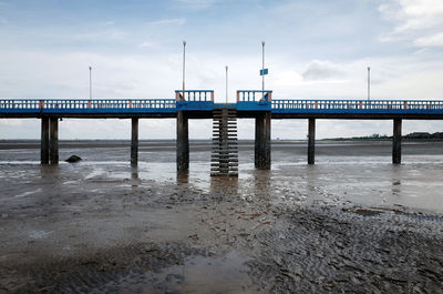 Pier over sea against cloudy sky