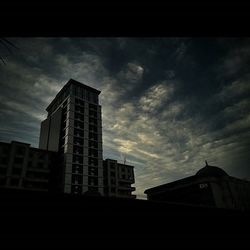 Low angle view of building against cloudy sky