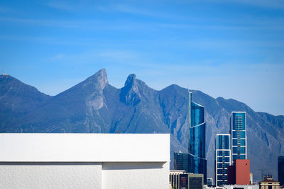 Buildings in city against blue sky