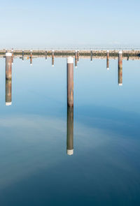 Wooden post in sea against clear sky