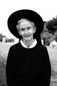 Portrait of smiling old woman standing against hat in traditional costume brittany 