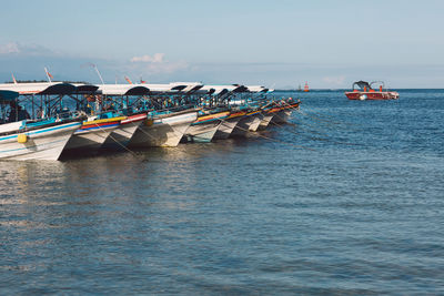 Boats moored in sea against sky