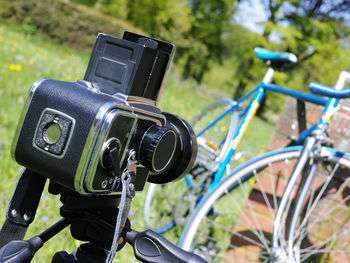 Close-up of camera and bicycle on field