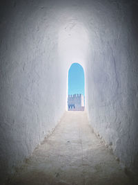 Empty alley amidst buildings in tunnel