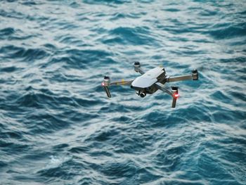 High angle view of drone flying over sea