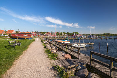 Sailboats moored in river against sky